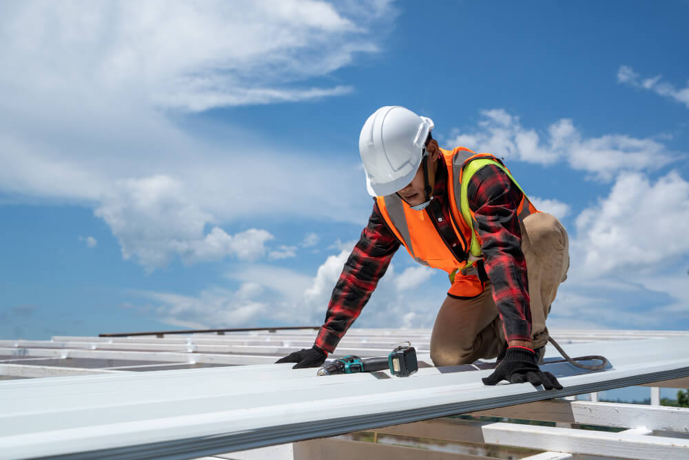 Construction Worker Wearing Safety Harness Working At High Level 